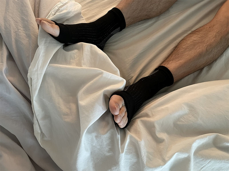 man wearing Copper Relief Socks in bed